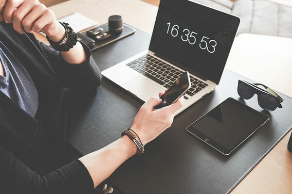 Person using iPhone in front of MacBook